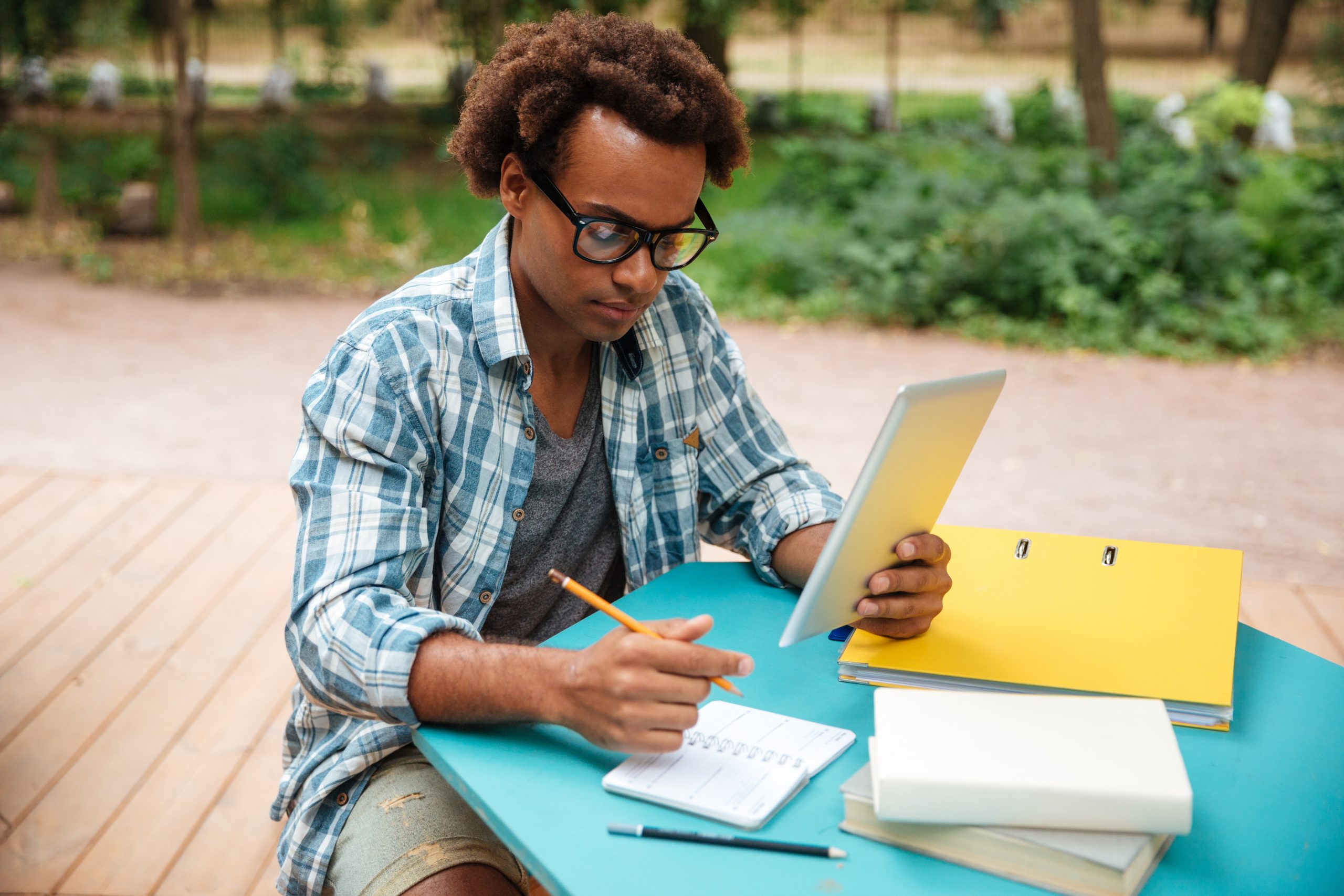 graphicstock-serious-african-young-man-writing-and-learning-in-the-park_HOfqxMhr3l-scaled-1
